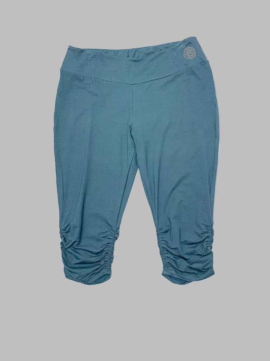 Cropped bamboo fabric leggings in a solid blue color with a gather at the hem.